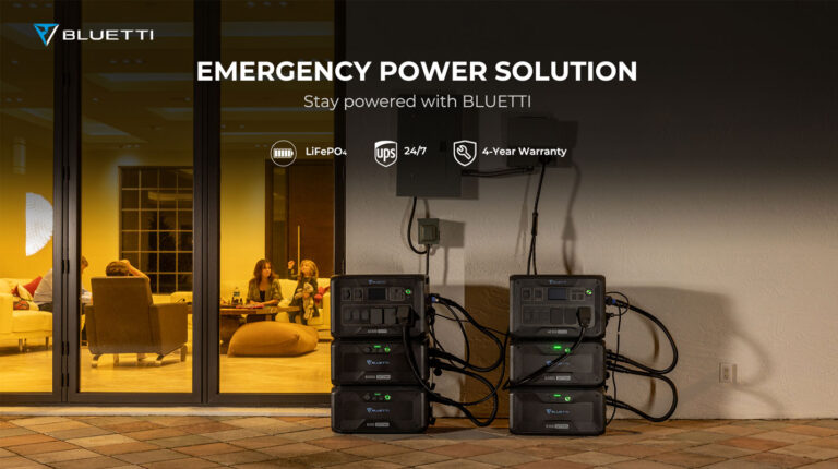 portable powerstation Bluetti zwarte stapelbare thuisbatterijen B300S en B300 verbonden in serie voor noodstroomvoorziening bij een woning met glazen schuifpui en mensen binnen zichtbaar op de achtergrond