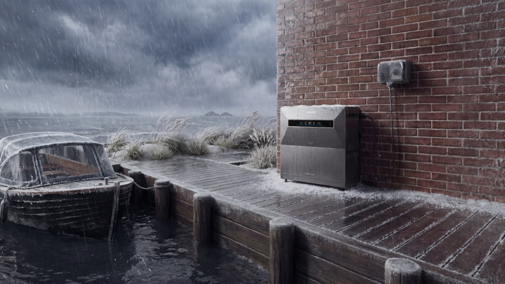 Twijfel je over een thuisbatterij buiten plaatsen? Portable powerstation Anker Solix zwart tegen bakstenen muur bij stormachtig, nat weer aan waterkant met besneeuwde oude houten boot en grijs bewolkte lucht